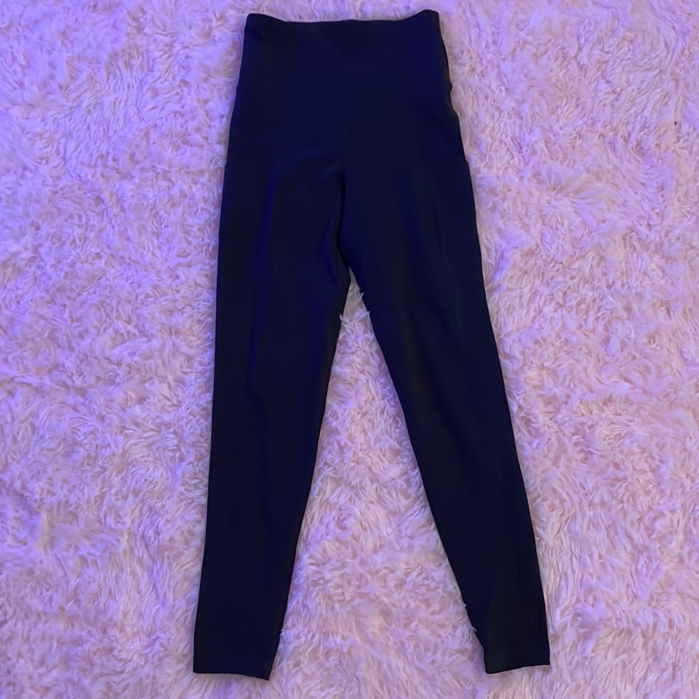 Blackish grey leggings with side pockets.